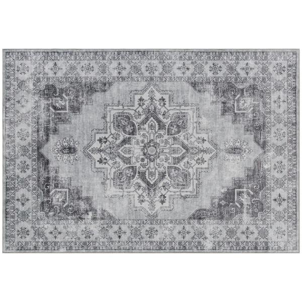 Grey vintage area rug with ornate central medallion and distressed geometric border