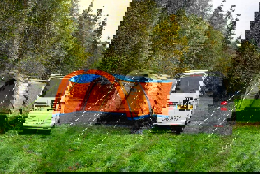 An image of the OLPRO Orange Cocoon Breeze Campervan Awning Extension attached to the Cocoon Breeze that has been fixed to a VW Campervan.