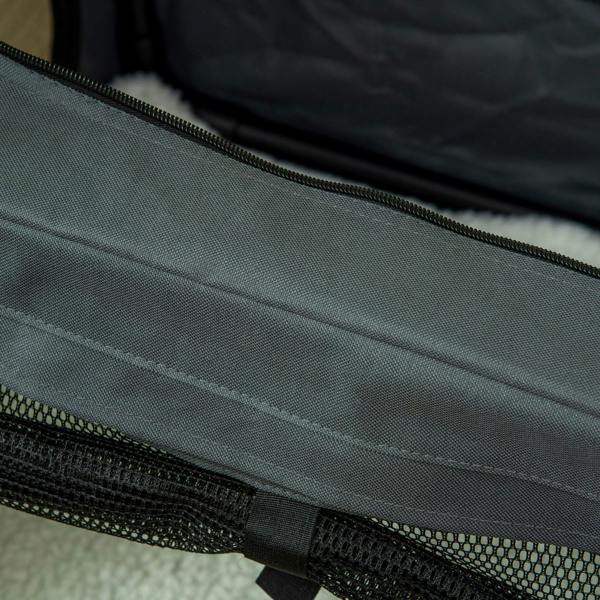 Close-up of grey pet carrier mesh panel with black zipper seam
