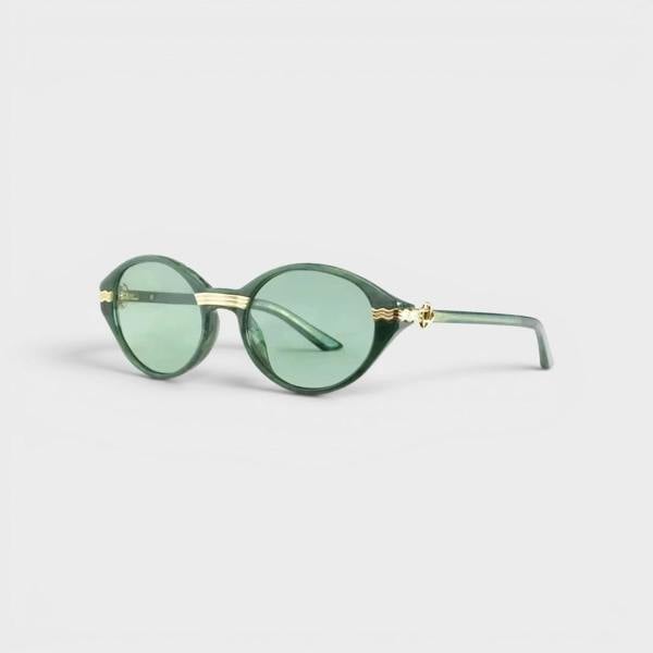 Supplied Fashion Cannes sunglasses featuring round green lenses and elegant gold-tone metal accents on a dark frame.