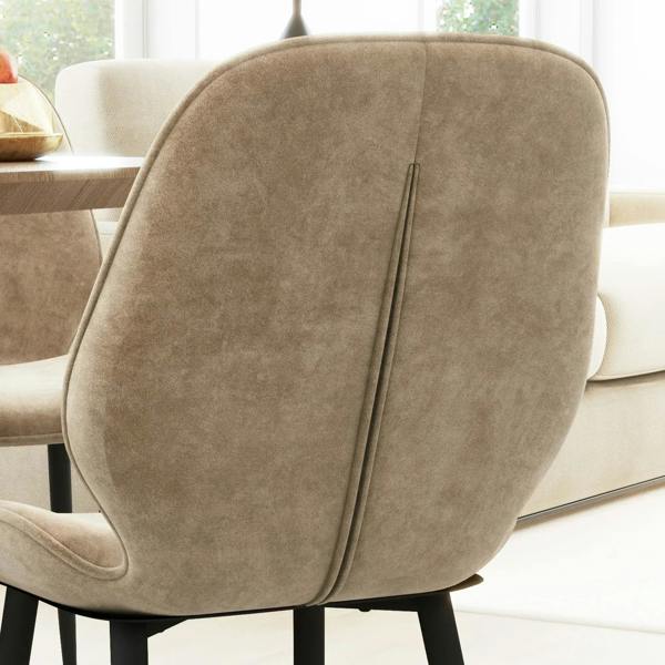 Light brown velvet dining chair backrest with vertical seam detail and black legs