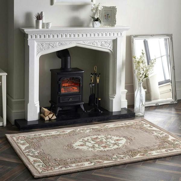 White fireplace with black stove, decorative rug, and mirror in a room.