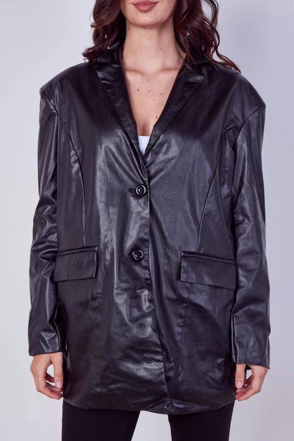 A woman wearing an oversized black faux-leather blazer with a glossy finish, three front buttons, and flap pockets, shown against a light gray studio background.