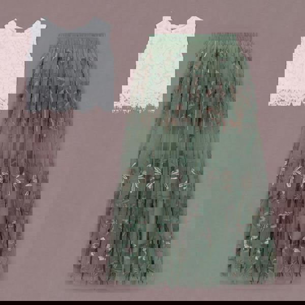 White lace top and green floral skirt on a pink background