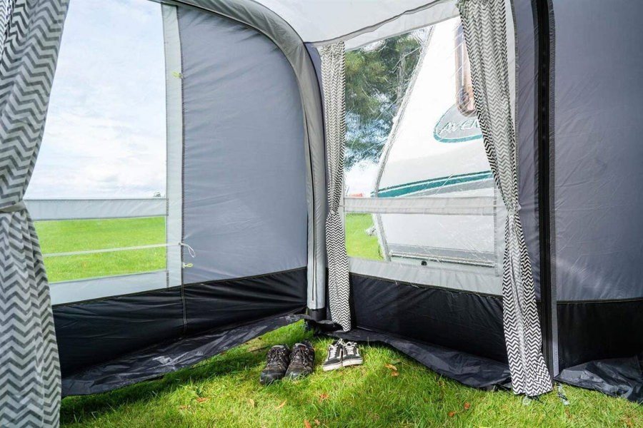 The inside corner of the View 420 Caravan Inflatable Porch Awning With Porch Extension from OLPRO showing the windows and two pairs of trainers.