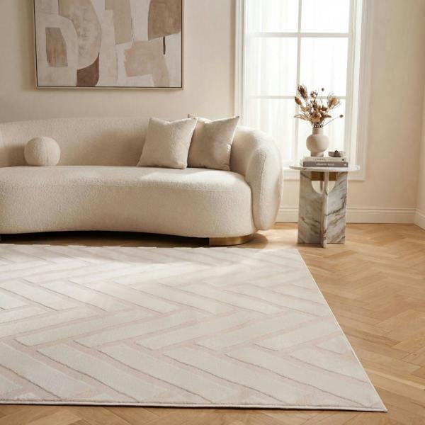 Modern living room with a beige sofa, abstract art, and a patterned rug.