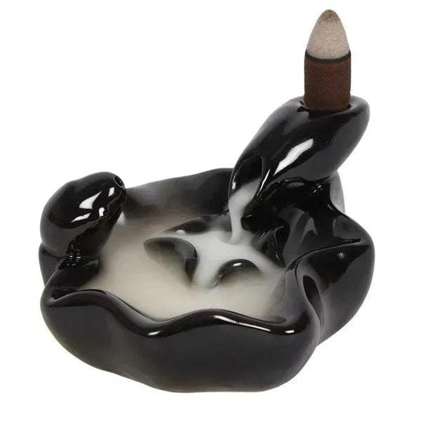 Glossy black hand-shaped incense burner with open center bowl and incense cone