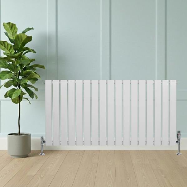 Flat single column radiator in sleek white finish, 600 x 1190mm, with vertical slats and chrome valves, positioned beside a potted plant on wooden floor
