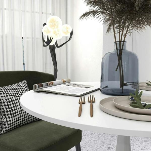 White round dining table with pedestal base, styled with plates and decor