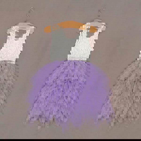 White lace top and purple tulle skirt dress on a hanger against a plain background