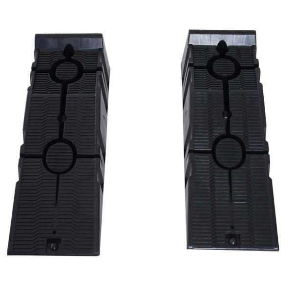 Pair of black plastic car ramps with circular grip details and deep traction ridges