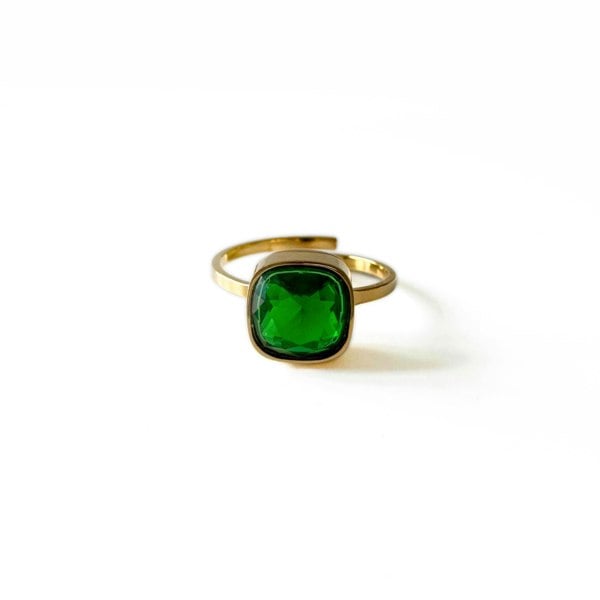 Gold ring with a green gemstone on a white background