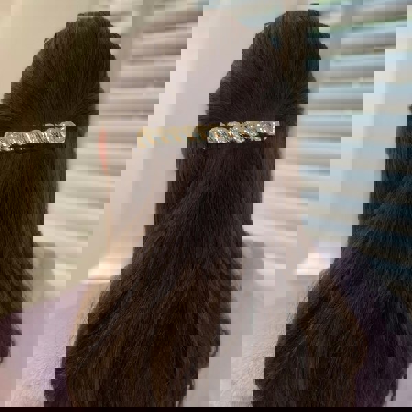 Silver hair barrette, large clip design, polished metallic finish, curved shape, strong clasp fastening, styled in half-up brunette hair, elegant decorative accessory
