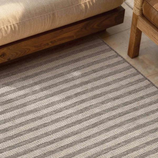 Striped rug with a sofa and wooden furniture in the background