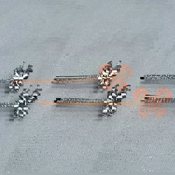 Gold hair slides, butterfly design, champagne crystal wings, long slim barrette style, rhinestone detailing along stem, sparkling decorative accessories, elegant vintage inspired look
