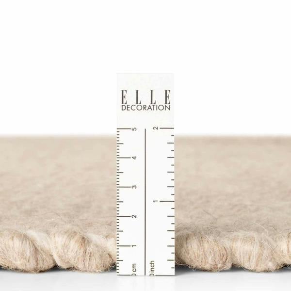 Textured fabric sample with a ruler for measurement and 'ELLE Decoration' branding.