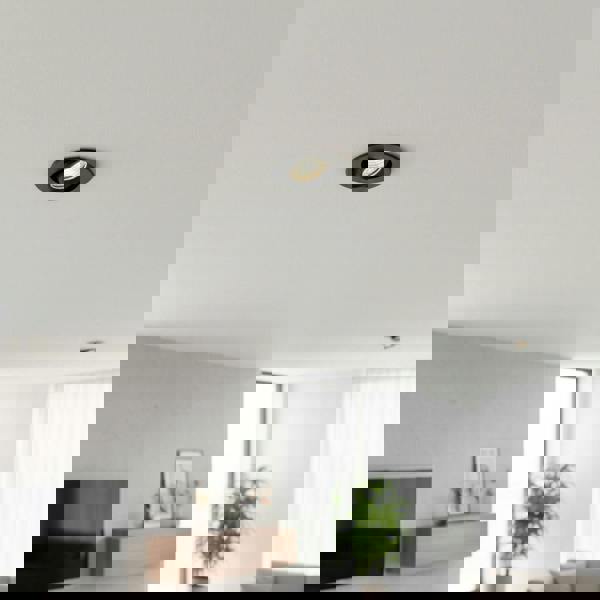 black IP65 LED downlight fitting mounted in the ceiling of a living room