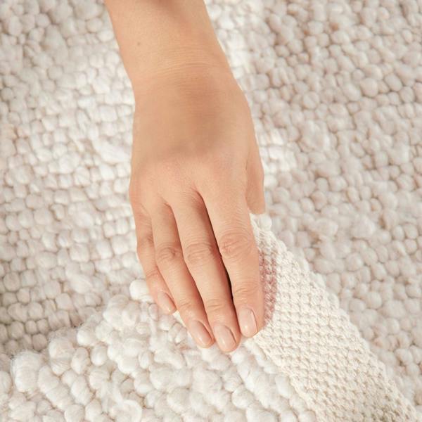 Hand touching a textured white surface