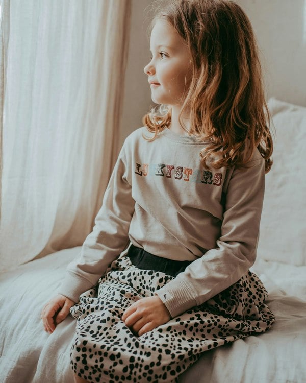 Girl wearing unisex organic cotton kids long-sleeve sweatshirt