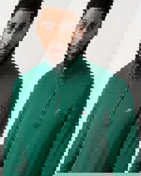 close up shot of a model wearing a GANT Mens Classic Cotton Half Zip Jumper in Deep Forest Green