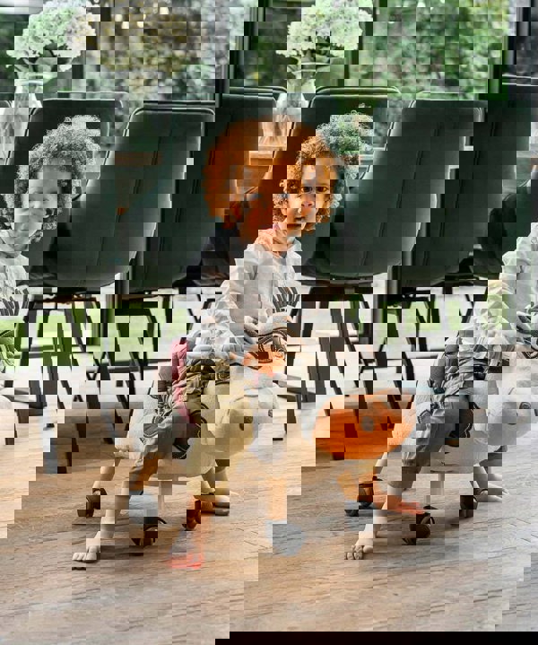 1 year old boy on moobert cow on wooden floor 