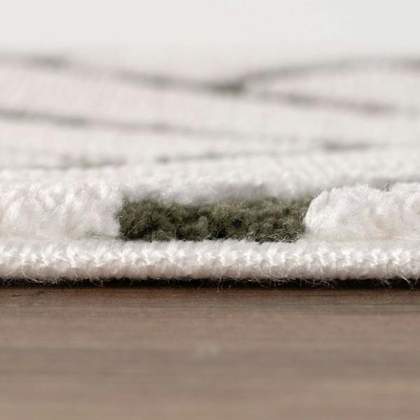 Close-up of a textured white rug on a wooden floor
