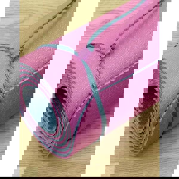 Rolled up pink Fitness Mad Evolution yoga mat with textured surface and gray trim