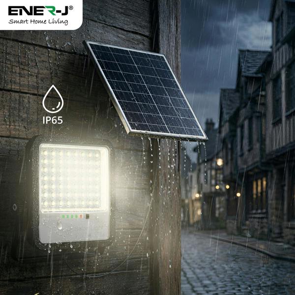 Solar light fixture on a building exterior with a dark sky and cobblestone street.