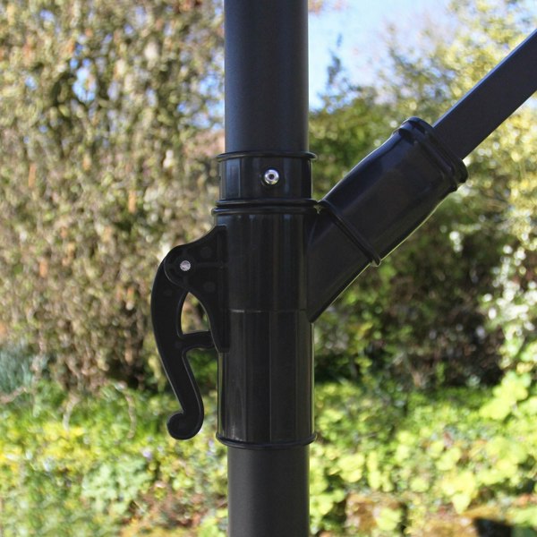 Close-up of the adjustable black parasol mechanism, showcasing the durable plastic handle and sleek design against a lush green backdrop