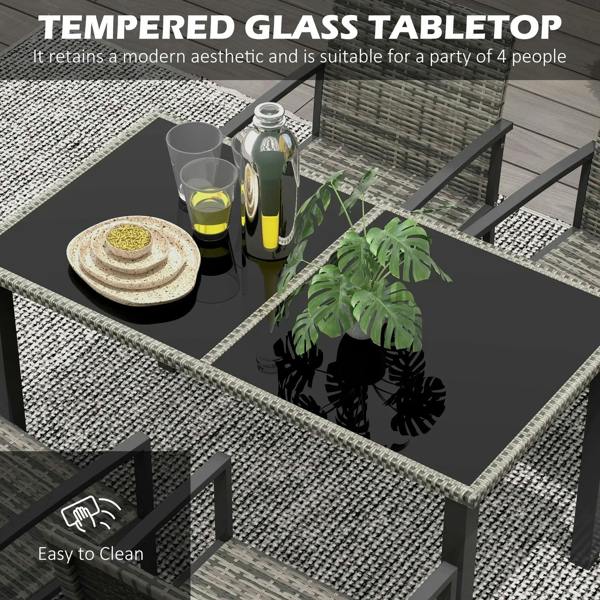 Tempered-glass outdoor dining table with grey woven chair backs and drinks