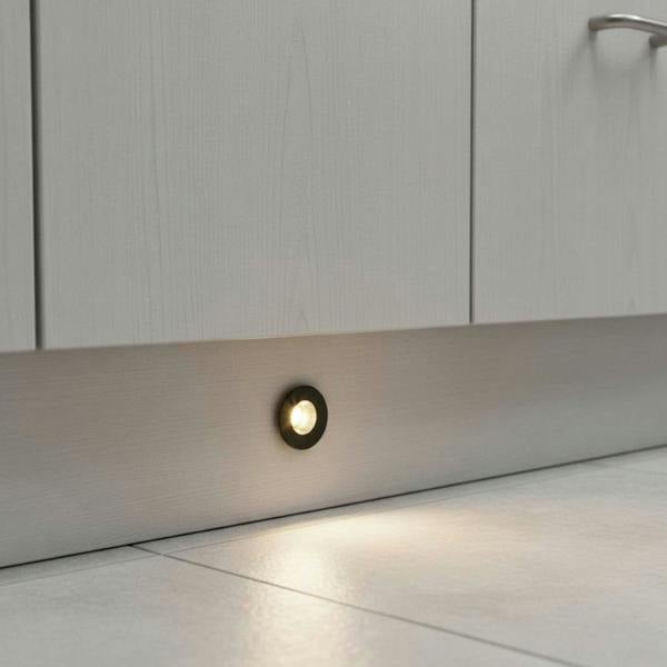 black LED plinth light recessed into a white kitchen kickboard 
