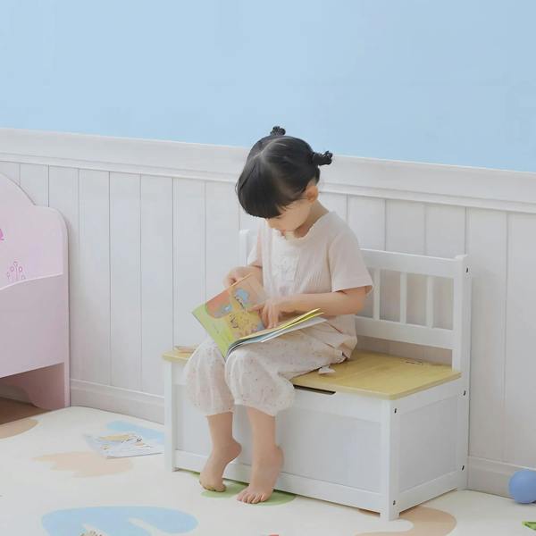 Child reading on a white storage bench with light wood top