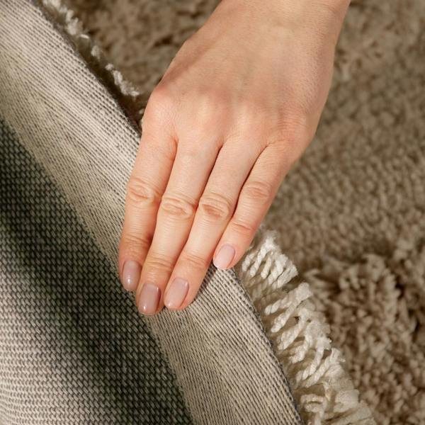 Close-up of a hand resting on a textured surface with a neutral color palette