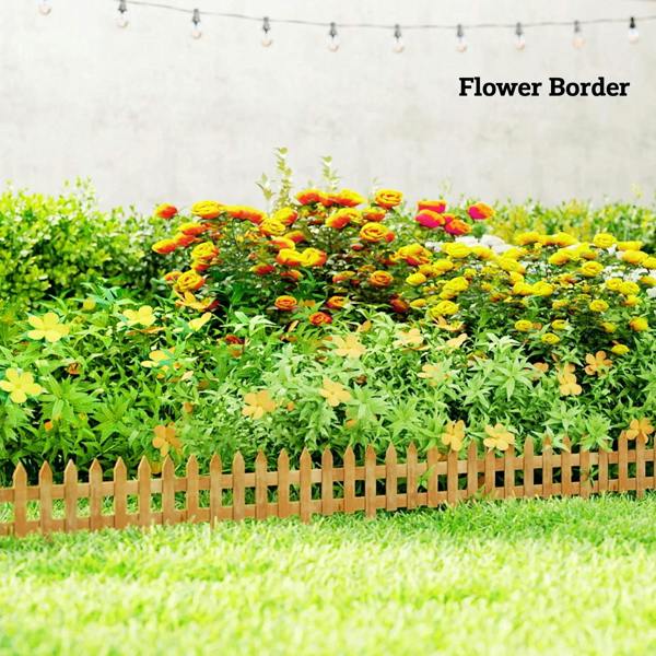 Brown wooden picket fence border edging separating flower bed plants from lawn