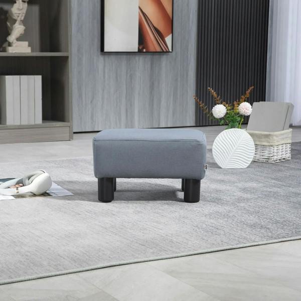 Grey upholstered footstool with padded seat and dark legs on a rug