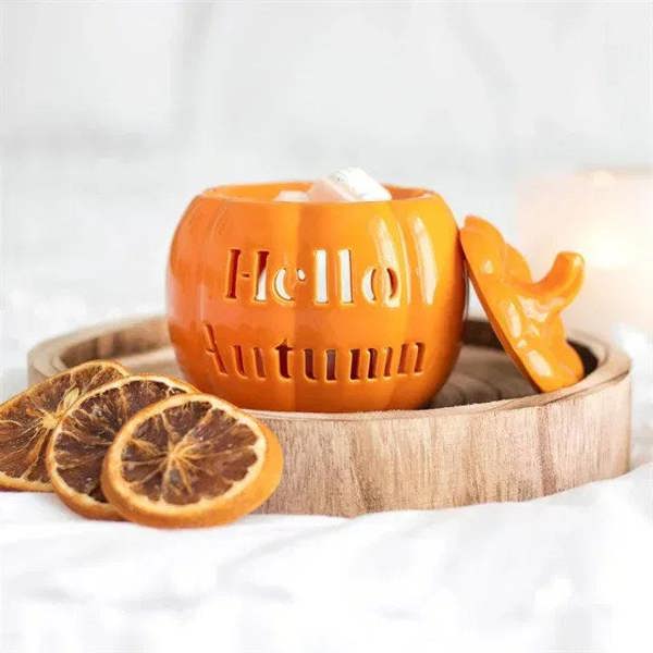 Orange pumpkin-shaped oil burner with lid and cutout lettering