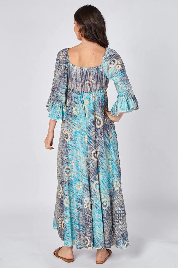 Woman wearing a long, patterned dress on a white background