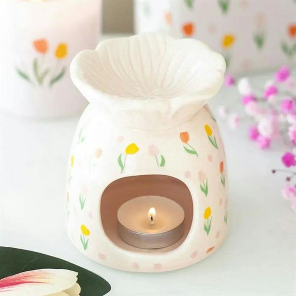 White tulip-print wax warmer with scalloped top and lit tea-light in round opening