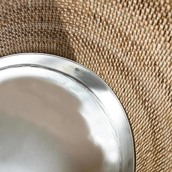 Close-up of handwoven rattan planter with removable metal liner insert for indoor plant use
