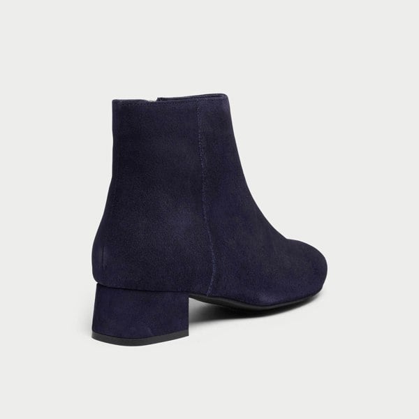 Navy blue ankle boots on a light gray background