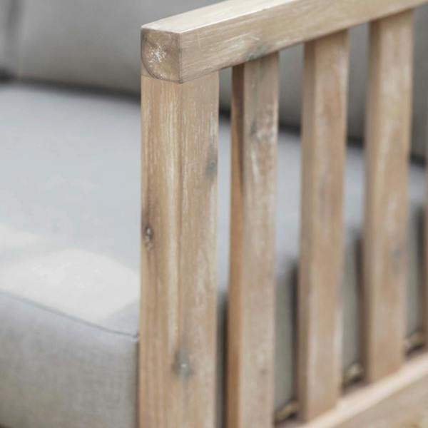Close-up of the oak-wash oiled finish on the slatted arm of a whitewash acacia garden sofa.