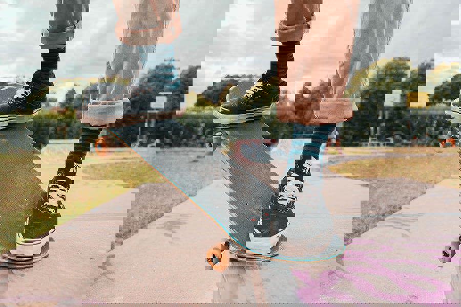 Person on a skateboard wearing green and black stripe socks with a park background