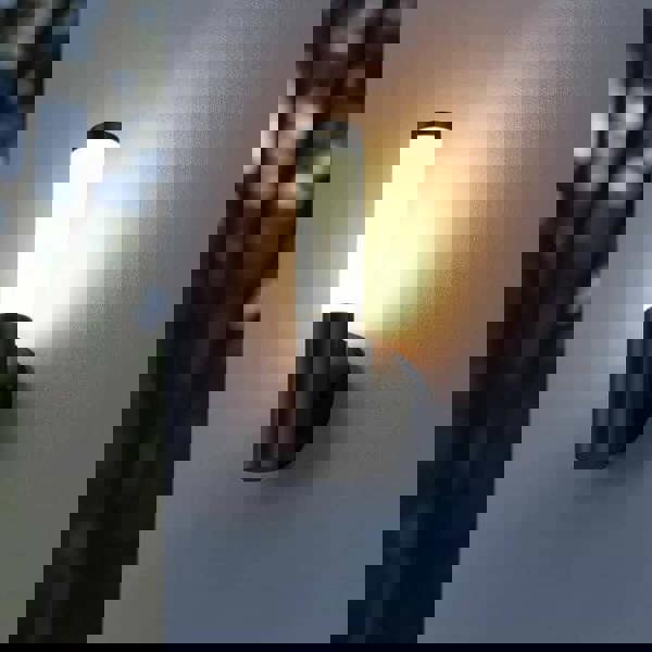 black outdoor wall lantern light installed on the exterior wall of a house on a white wall 