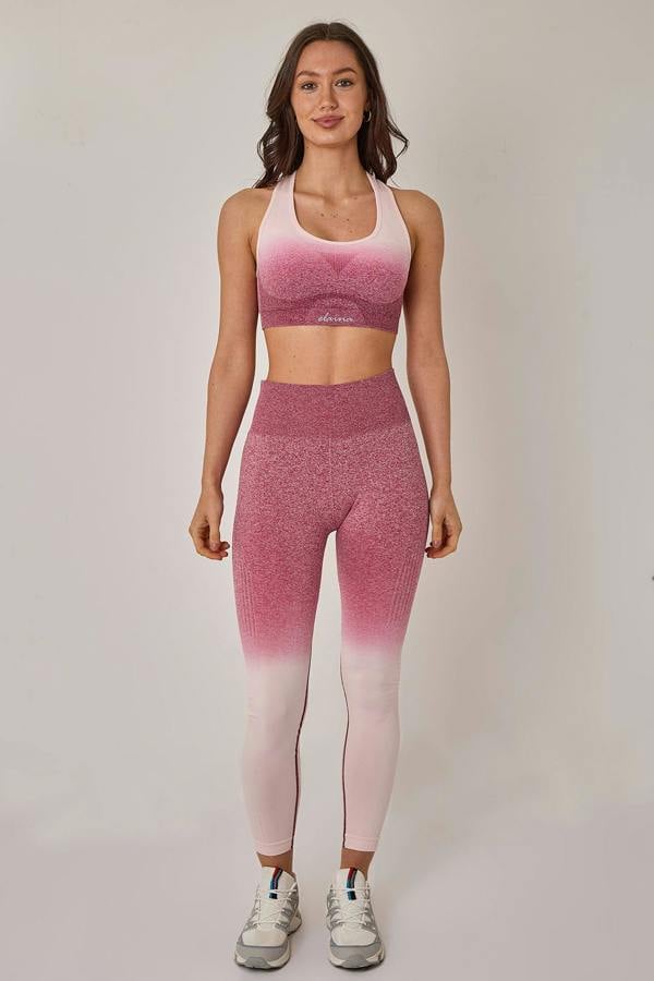 Woman wearing a pink and white gradient athletic outfit on a plain background