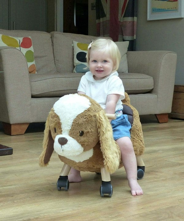 Little girl riding on Peanut Pup Animal Ride On Toys for toddlers