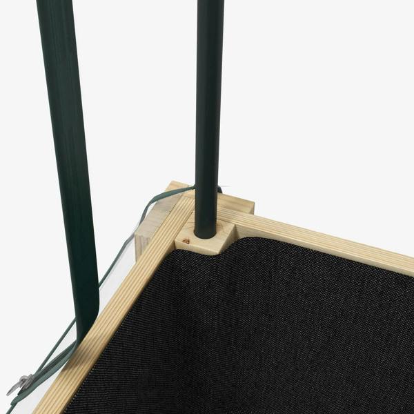 Corner of raised planter box greenhouse frame with black fabric bed liner