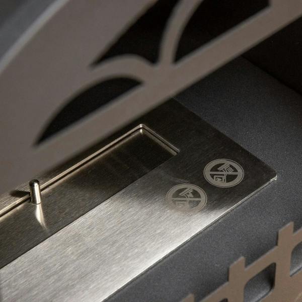 Stainless steel burner tray close-up inside black ethanol fireplace with vented slots