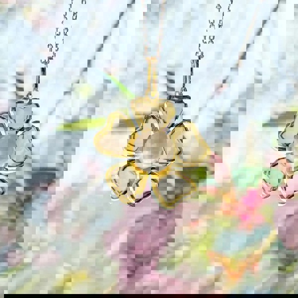 Gold vermeil pearl and mother of pearl pendant necklace displayed among colourful background.