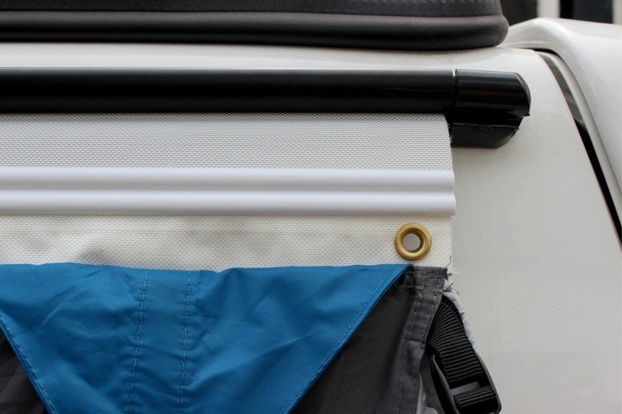 The OLPRO 6-6mm Awning Drive Away Kit attached to an awning rail on a campervan awning, showing the Kador strip and figure of 8 with the awning attached.