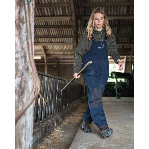 Farmer wearing the Navy Hoggs of Fife Waterproof Bib and Brace whilst mucking out